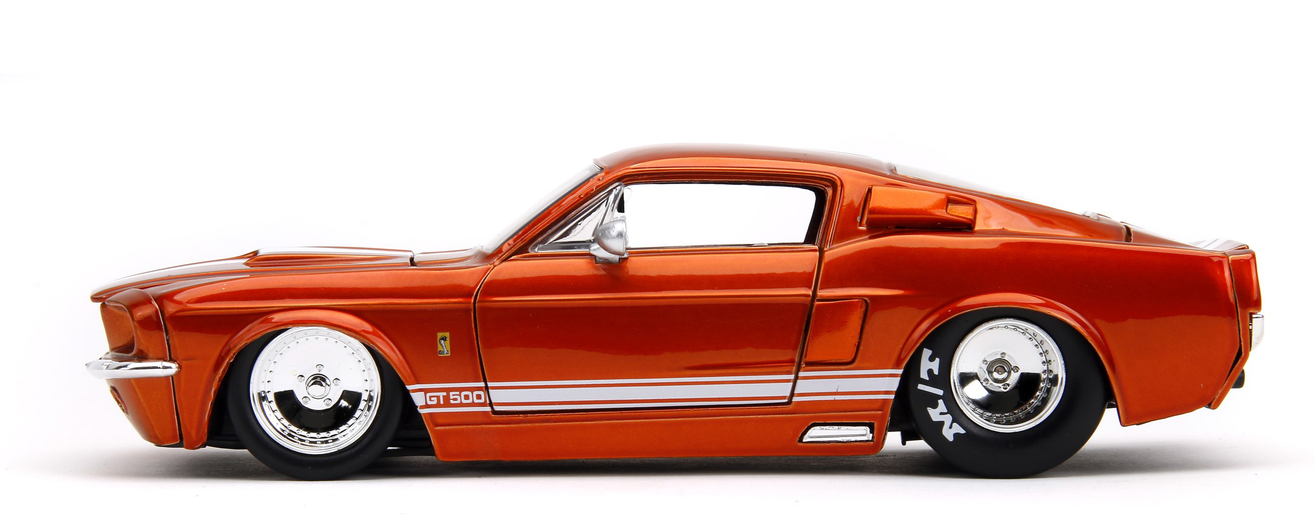 Der Shelby GT 500 aus dem Jahre 1967 ist in Kupferfarbe lackiert. Die typischen Shelby Doppelstreifen ber die Mitte des Autos sind in wei angebracht. Zierstreifen mit dem GT 500 Logo wurden ber dem Seitenschweller angebracht. Motorhaube lsst sich ebenso wie Tren und Kofferraumdeckel ffnen. Die verchromten Ganzscheibenfelgen sind fr das Auto, wie auch die verchromten Seitenspiegel der Hingucker. 
