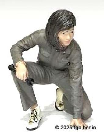 AMD-P 70105 Beim getunten Auto ist es wichtig den Freiraum am Kotfl�gel zu kontrollieren. Paula hat dazu eine Taschenlampe zur Hand. Zum gr�nen Overall tr�gt sie wei�e Sportschuhe. 