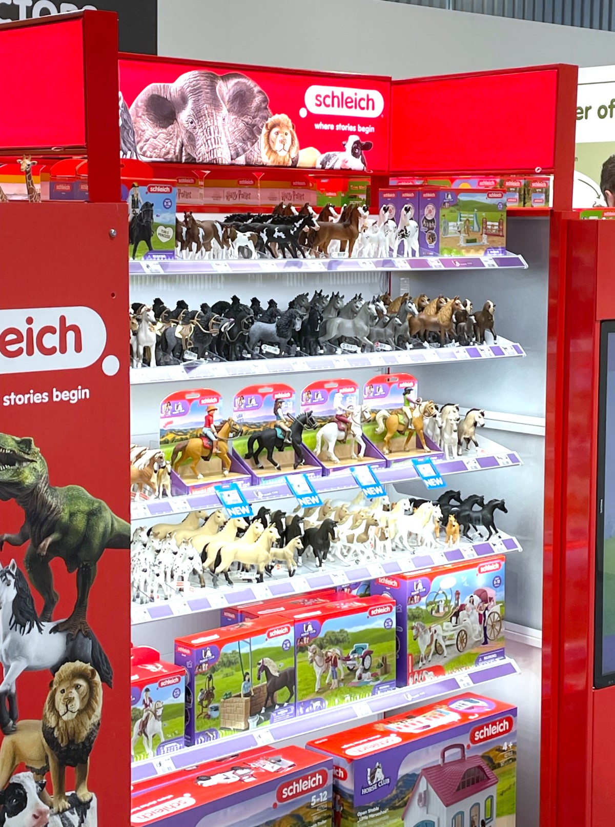 Display fr Schleich Figuren auf der Spielwarenmesse in Halle 6. Gut zu erkennen sind die Einzeltiere von Pferden, einmal ohne und einmal mit Reitern:innen. Auch Sets fr den Bauernhof werden angeboten.