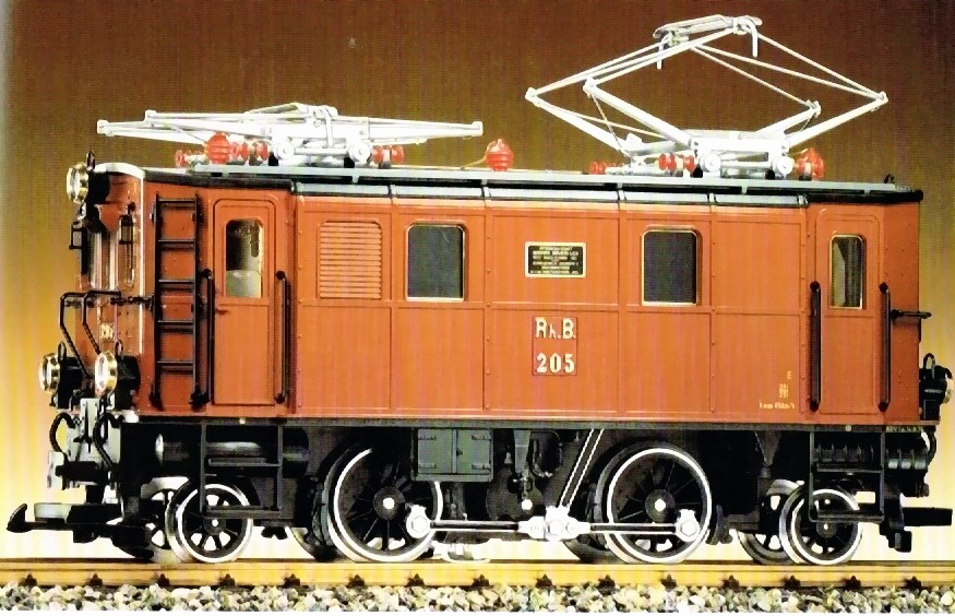 Ge 2/4 RhB - 4 achs. Elektro-Lokomotive. Hellbraunes Gehuse, Leiter und Griffstangen schwarz. Dach und beide Dachstromabnehmer silberfarben, Isolatoren rot. Fabrikschild zwischen den Fenstern. 5-Volt Elektronik. Lichtwechsel (3 x Spitzenlicht - 1x Schlussleuchte. Lok Speichenrder schwarz.