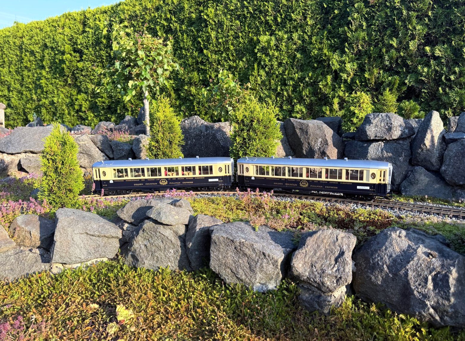 Auf dem Gleis und in der Modellbahnlandschaft  sehen die beiden Golden Mountain Pullman Express Wagen, Set 1, Art. Nr. 36660, imposant aus. 