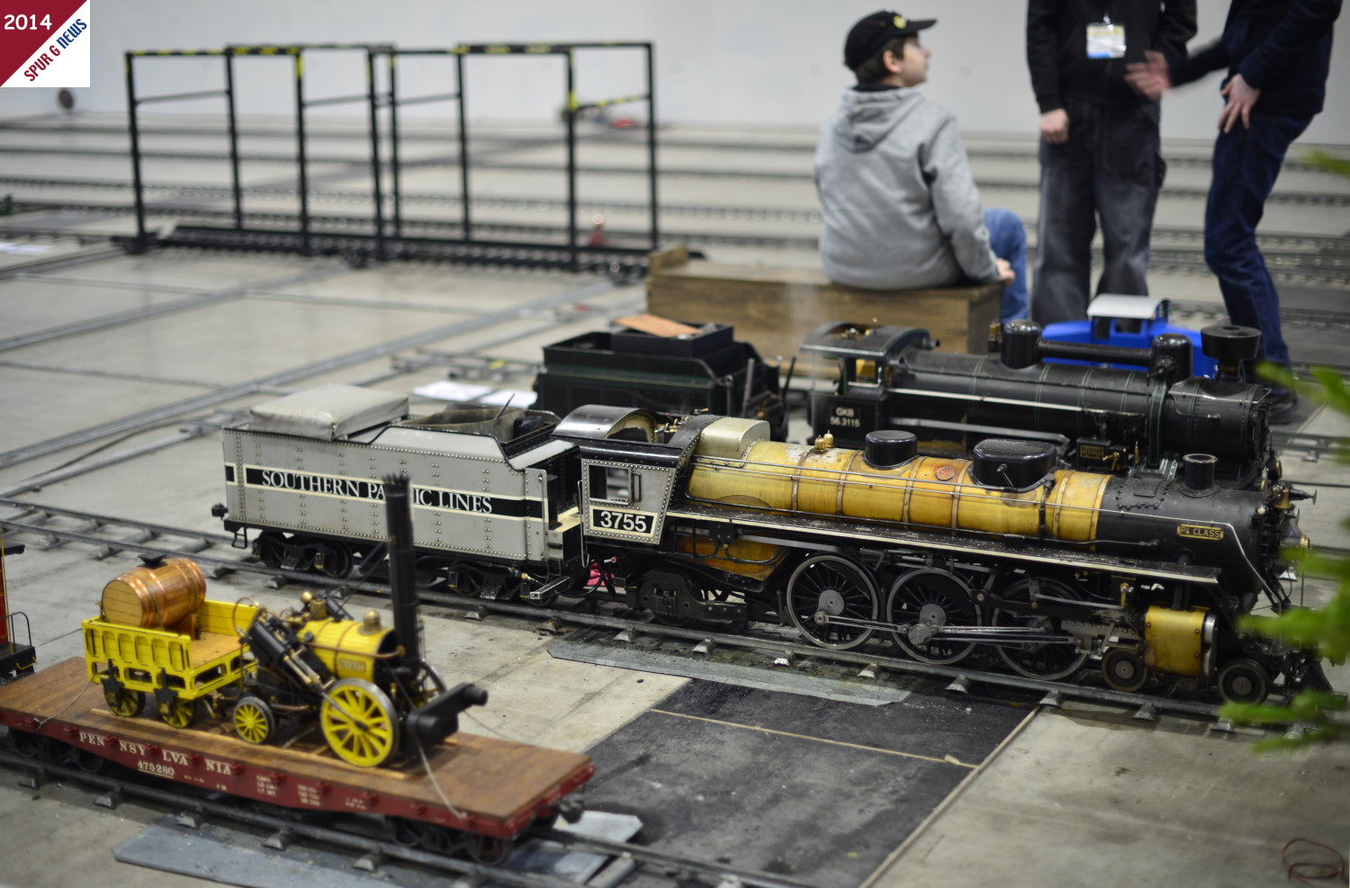 Im Vordergrund eine "verladende" Ur-Lokomotive - die Rocket. Daneben eine US-Schepptenderlok der Baureihe Pacific mit der Achsfolge 4-6-2 und, leicht verdeckt, eine sterreichische Lokomotive GKB 56.3115. 