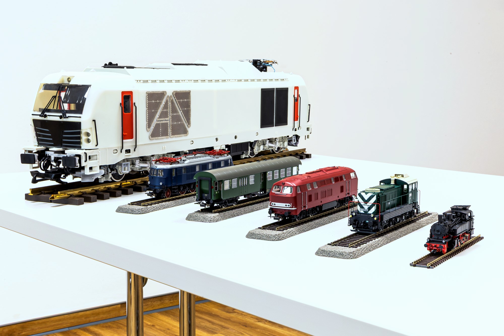 2026-01-20 Jahrespressekonferenz_Bild 2, Quelle PIKO Spielwaren GmbH  Von links nach rechts: die G Zweikraftlok BR 248 (Vorserienmuster), die H0 Elektrolok BR 119 (Vorserienmuster), ein H0 vierachsiger Umbauwagen 4yg (Serienmodell), die H0 Diesellok BR 215 (Vorserienmuster), die H0 Diesellok M44 (Serienmodell) und die TT Dampflok BR 91.3 (Vorserienmuster). 