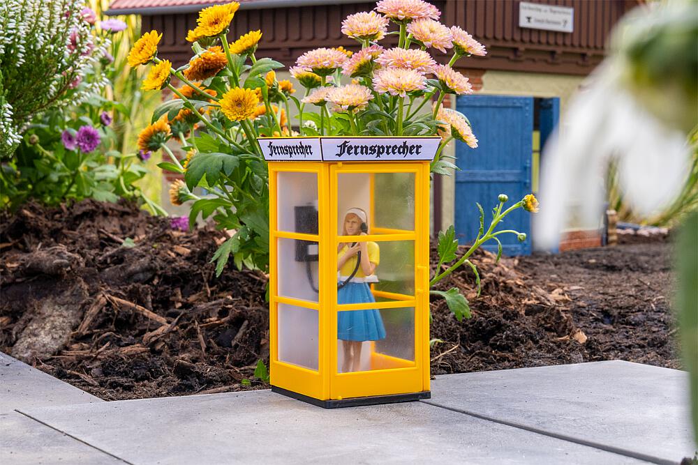 POLA - Art. Nr. 333231 - Telefonzelle mit Figur �Hallo?� - Leuchtend gelbe Telefonzelle mit drei verglasten Seiten und klassischem �Fernsprecher� Schild in nostalgischer Schrift. Im Inneren steht eine liebevoll gestaltete Figur, den H�rer am Ohr, ganz ins Gespr�ch vertieft. Die beweglichen T�ren lassen sich �ffnen und schlie�en und verleihen der Szene zus�tzliche Authentizit�t. Ideal als belebtes Detail am Stra�enrand oder auf dem Dorfplatz, um eine Szene voller Nostalgie zu schaffen.