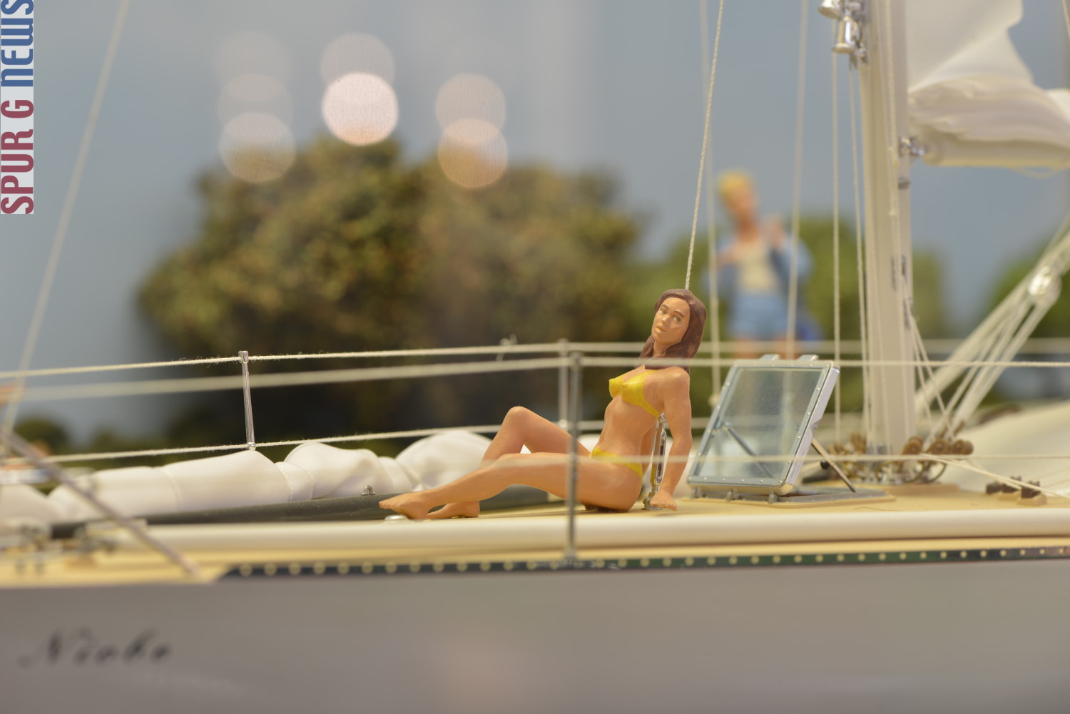 Badenixe im gelben Bikini - der ist nur aufgemalt - am Schiffsdeck. 