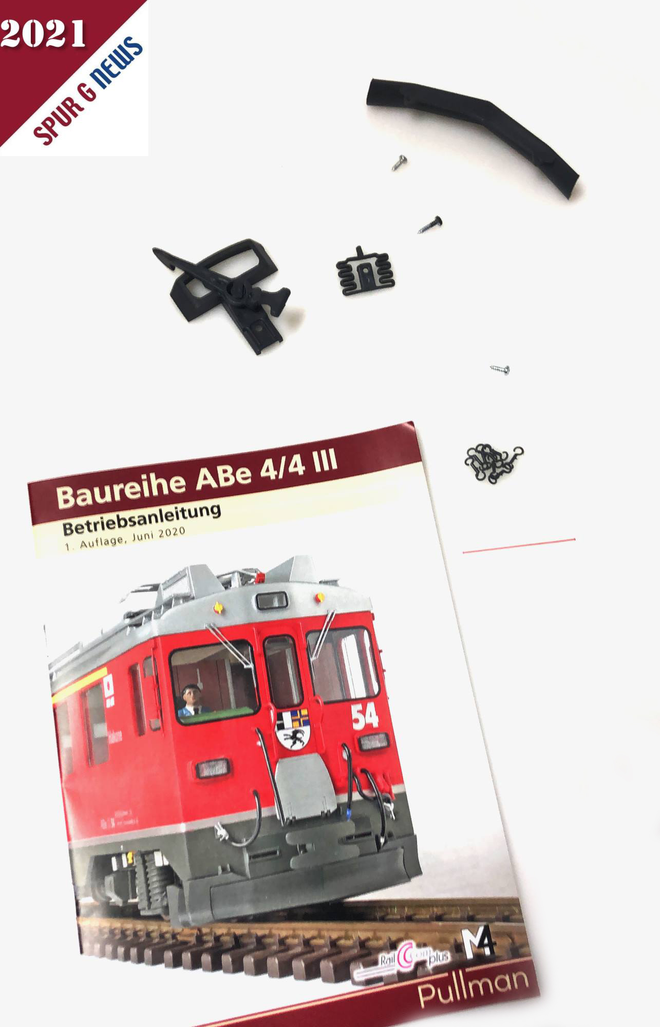 Beilage zum Triebwagen ABe 4/4 III: Bedienungsanleitung mit Zubehörteilen wie Kupplung mit Schrauben, Schienenräumer und kleinen Haken. 