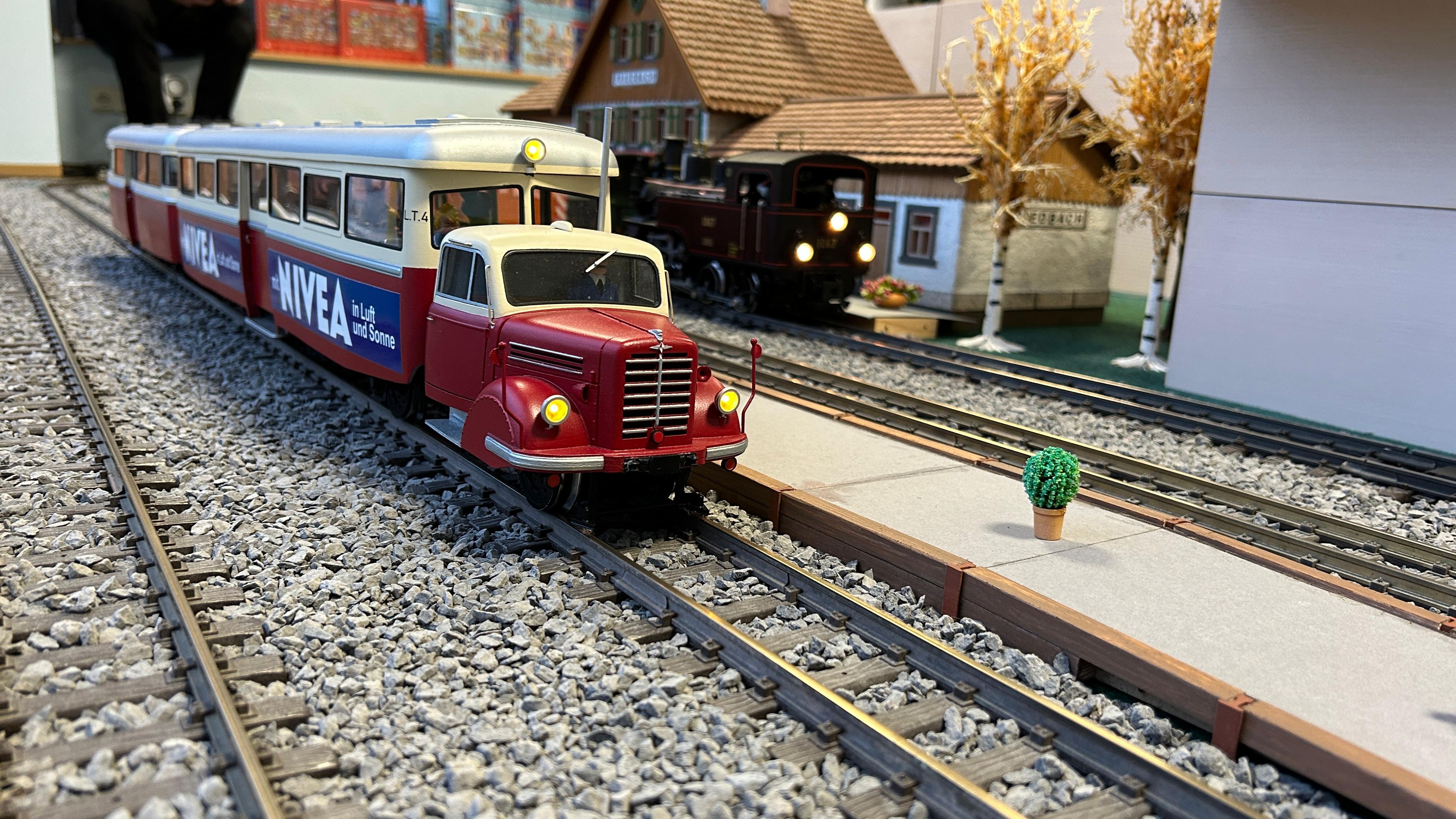 Der Sylter Leichttriebwagen L.T.4 in dunkelrot mit Anhnger - Modell aus dem Studio Raab - auf der Anlage im Modellbaustudio. Hier Bahnhof Friedberg. 