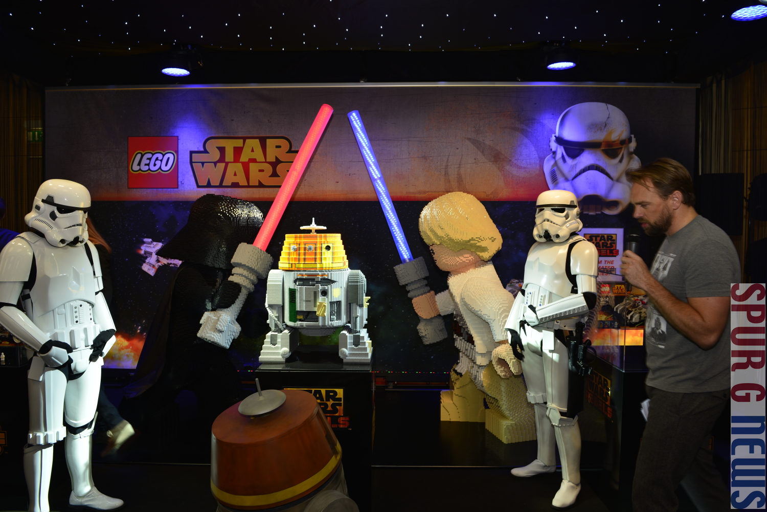 Lego hat fr die StarWars Rebell Serie eine neue Figur als LEGO Modell in einer Weltpremiere vorgestellt. Selbst eingefleischte StarWars Fans aus den USA oder Malaisia waren bei der Pressevorschau dabei. Rechts zwei Stormtrooper mit dem neuen kleinen Roboter und dem Moderator Steven Gtjen.