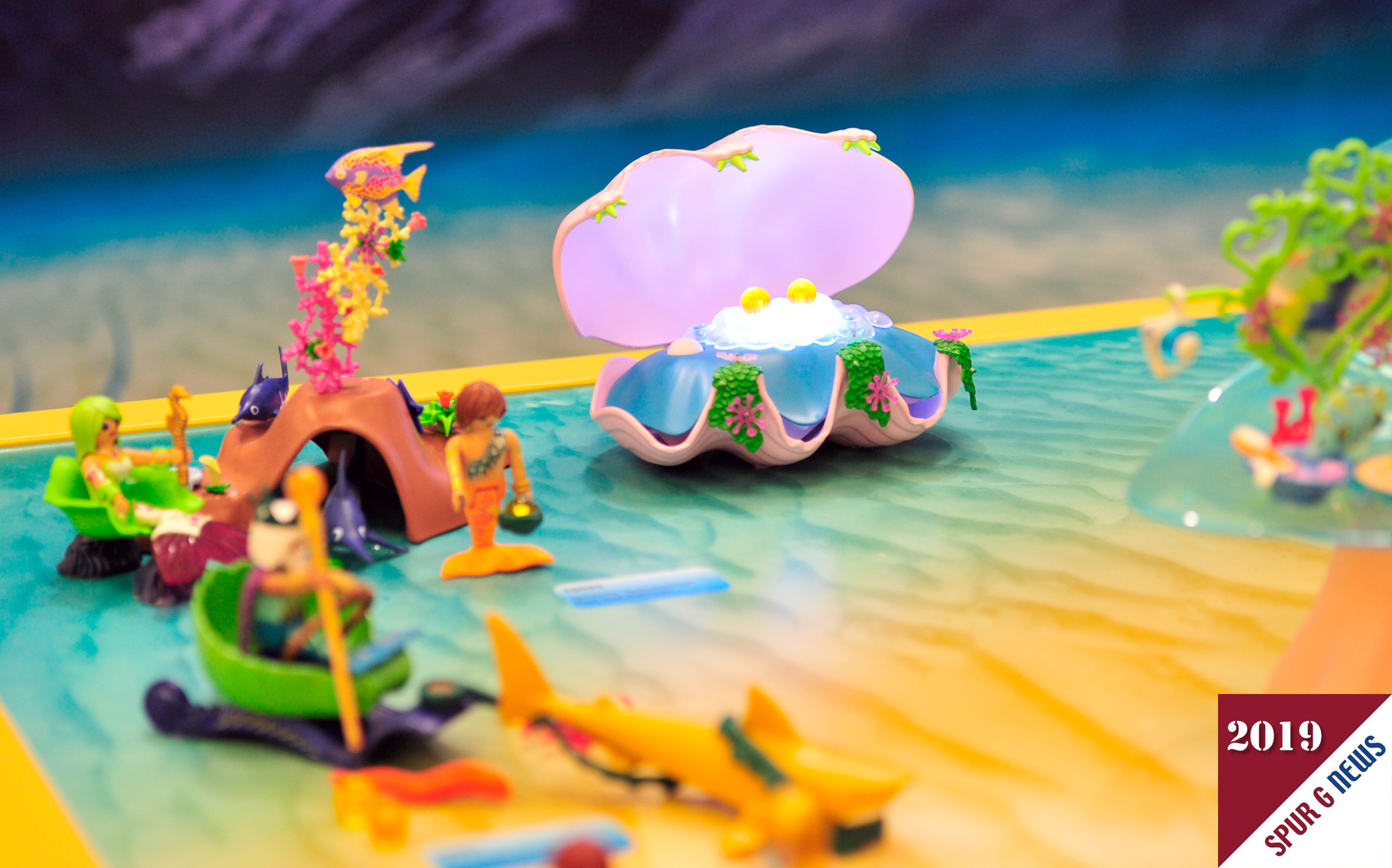 Fr den ToyAward 2019 in der Kategorie School Kids (6-10 Jahre) nominiert: Magical Mermaid World von Playmobil. Hier geht es um Meerjungfrauen und Meerjungmnner die in beleuchteten Muscheln Perlen vorfinden. Diese knnen dann ber eine Bahn von oben in die Unterwasserwelt mit Lichteffekten gerollt werden. Besonderheit an den Meerjungfrauen ist die abklappbare "Schwanzflosse". Somit kann die Meerjungfrau auch auf dem Grund gut stehen. 