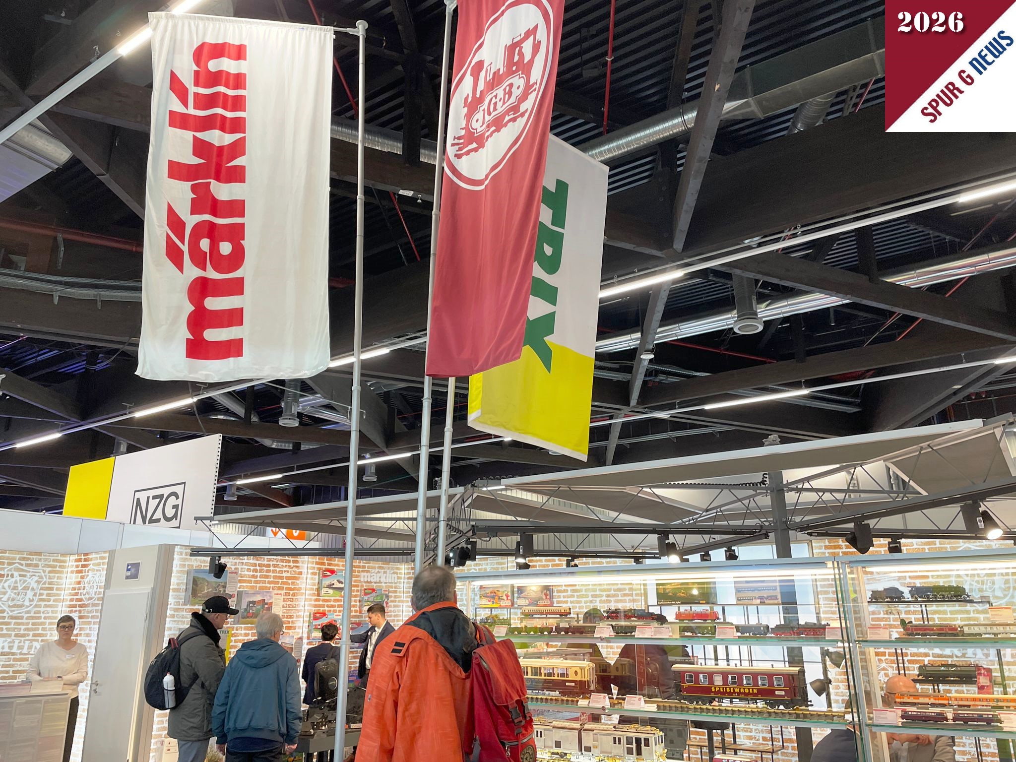 Zum 75. Jubil�um der Spielwarenmesse pr�stentiert sich M�rklin, Trix und LGB auf 75qm Ausstellungsfl�che. Von den LGB Neuheiten sind drei ausgestellt. Nachstehendes Foto zeigt den aufgelockerten Stand mit den Glasvitrinen und den obligatorischen Fahnen zur Erkennung der Marken. 