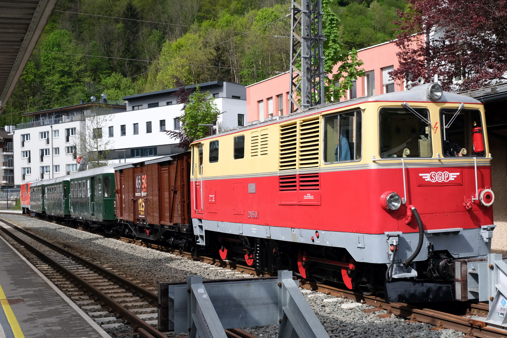 Ganzzug mit SGB 2095.01 in rot/beige Nr. 2095.01 mit  dem Jubiläumsgüterwagen PLB - GGm_s 601 (LGB Museumswagen 2023), mit 3 Personenwagen Bauart  B4ip_s, Nr. 354, Nr. 307 und Nr.306  und der Lok ÖBB 2095.04 der ÖBB in rot . 
