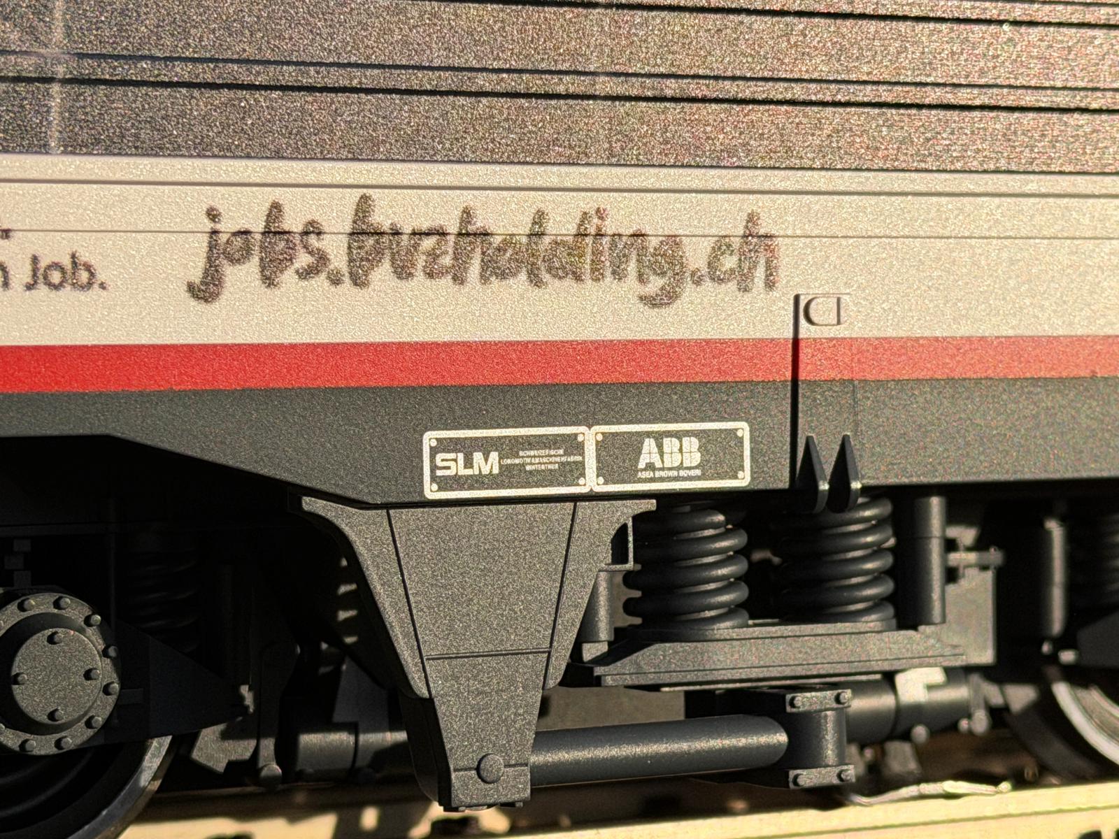 Teilansicht Drehgestellt mit den Fabrikschildern von SLM und ABB. Auch die Werbung ist aufgedruckt: jobs.bvzholding.ch