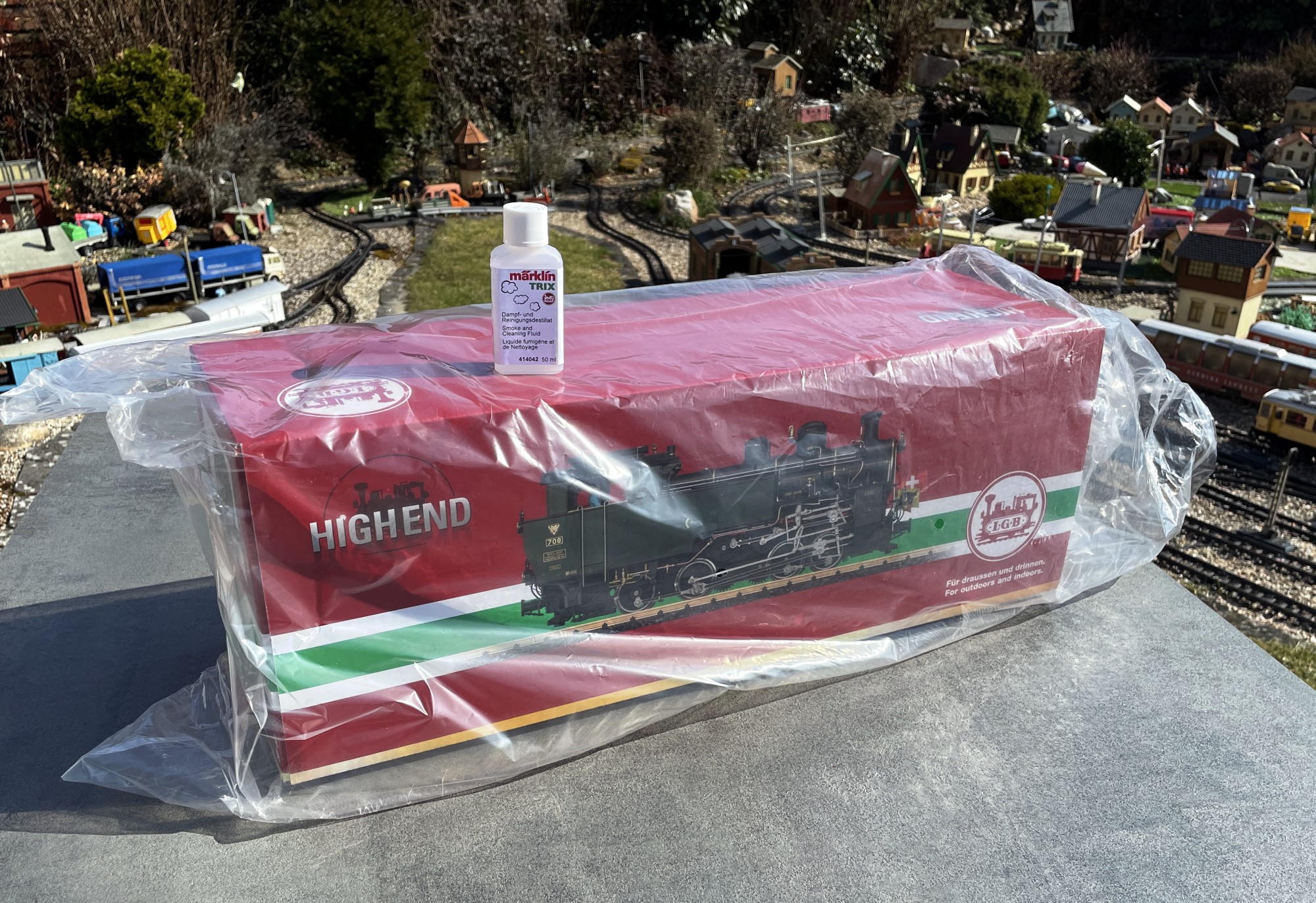 Im br�unlichen Umkarton ist neben den Styroporecken und Styroporteilen noch eine Flasche Dampflok�l zum Vorschein gekommen. Der �bliche rote Karton mit der wei�-gr�n-wei�en Bauchbinde war noch in Folie verpackt. 