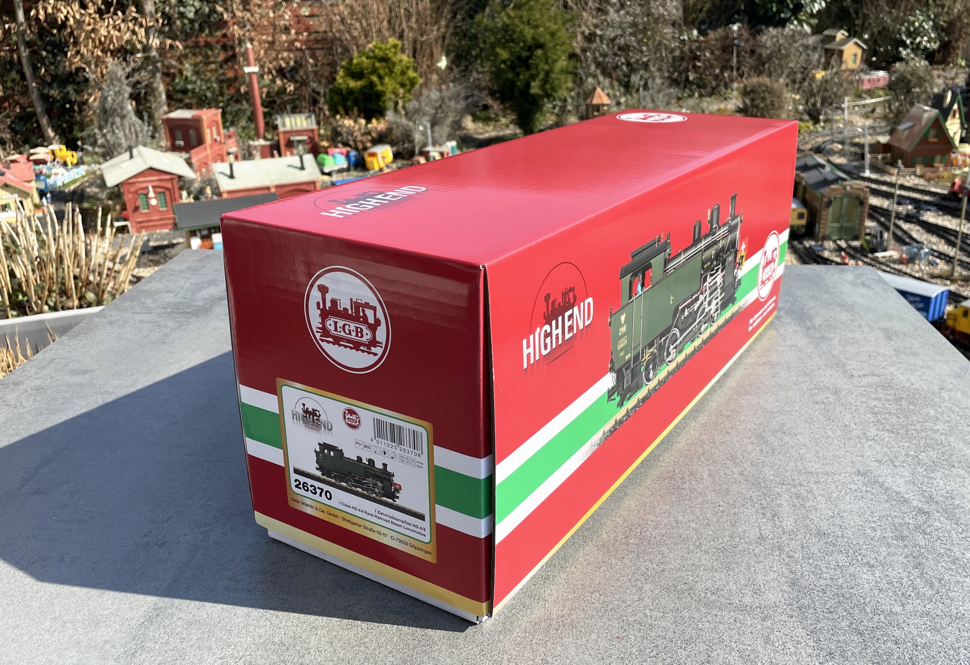 Der Verpackungskarton der HG 4/4 der DFB hat auf jeder Schmalseite einen Aufkleber. Hier die Seite mit Artikelnummer und Strichcode. Auf der anderen Seite ist nur die Lok zu sehen. Highend Metallmodell sticht auch schon auf der Seite des Kartons hervor. und die 6,3 KG sind nicht zu verachten. Bitte aufpassen, den Karton an der Unterseite anfassen zum Tragen. Seitlich angepackt kann der wei�e Unterkarton herausgleiten. 