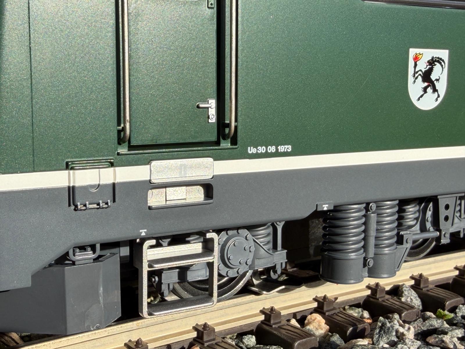 Der Einstieg in die Ge 4/4 II im grünen Kleid mit Aufstieg, Türgriffen und der zu öffnenden Tür. Auch das Wappen und die UE 30 06 1973.