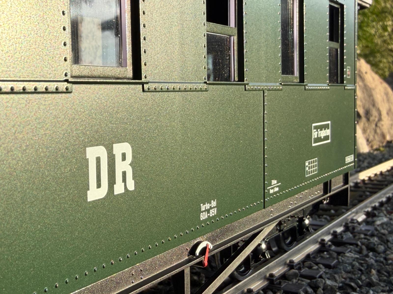 Detailansicht des LGB Art. Nr. 36371 - Personenwagen der DR - Bauart KD - Wagennummer 970-563. Gut zu erkennen sind die grünen Fensterrahmen sowie die Nietenbänder an den Fensterausschnitten und am unteren Rand des Tragrahmens.