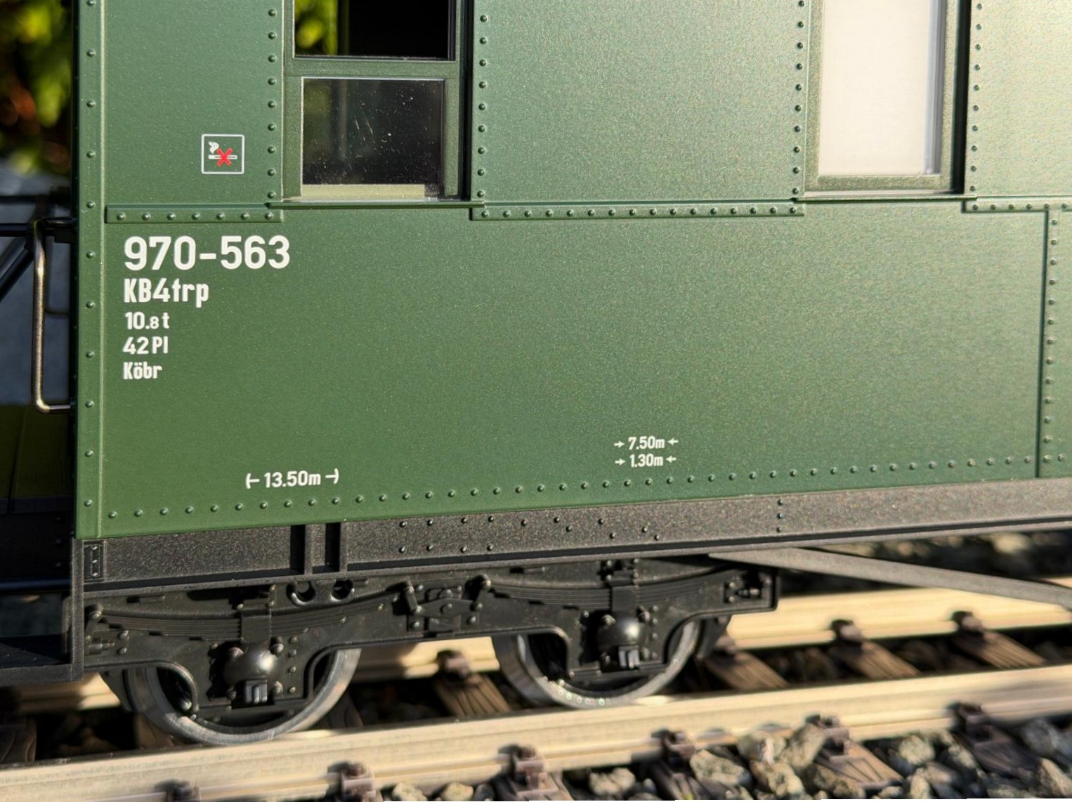 Detailansicht des LGB Art. Nr. 36371 - Personenwagen der DR - Bauart KD - Wagennummer 970-563. Sauber gedruckte Beschriftung an der Wagenseite. Nichtraucherpiktogramm, Wagennummer 970-563. Bauart KB4trp. 10,8 Tonnen mit 42 Plätzen. Köbr = Körtingbremse. Länge über Puffer 13,50 Meter im Original.