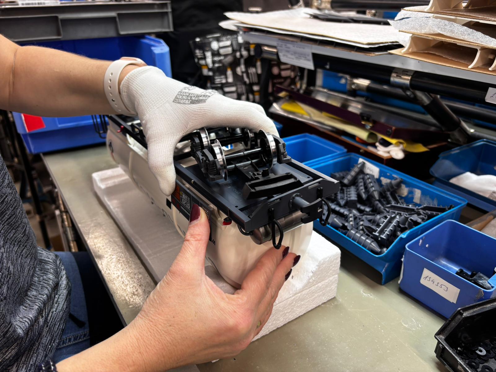 Die mit Metallrädern besetzten Drehgestelle werden noch ausgerichtet und verschraubt. Die vormontierte Bodenplatte wird hier auf die Kesselunterseite gesetzt. Die Drehgestelle werden dann noch ausgerichtet und verschraubt.