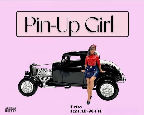 American Diorama - Pin-Up Girls, Betsy, Art. Nr. 76440, Locker auf einen Kotflügel oder die Motorhaube aufgestützt, ein Bein etwas hinter das andere geschoben, einen blauen rock mit roter Bluse und passender Schleife im braunen Haar.