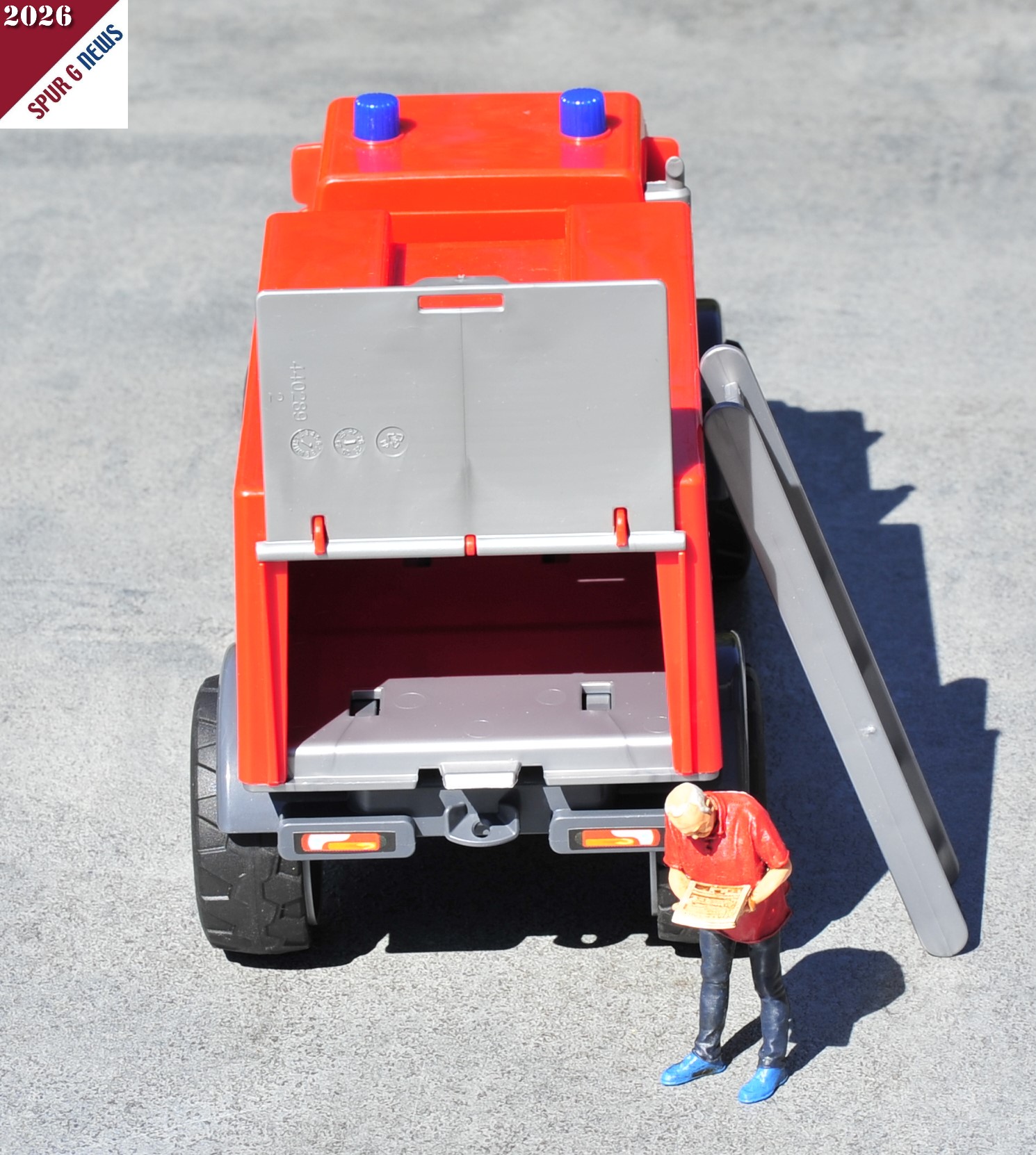Rückansicht des Mercedes-Benz Unimog Feuerwehr. Die Heckklappe des Kastenaufbaus kann geöffnet werden. Es ist jedoch keine Inneneinrichtung vorhanden. Die Leiter - rechts angelehnt - ist auf dem Dach untergebracht. (Die Figur ist nicht im Preis enthalten.)