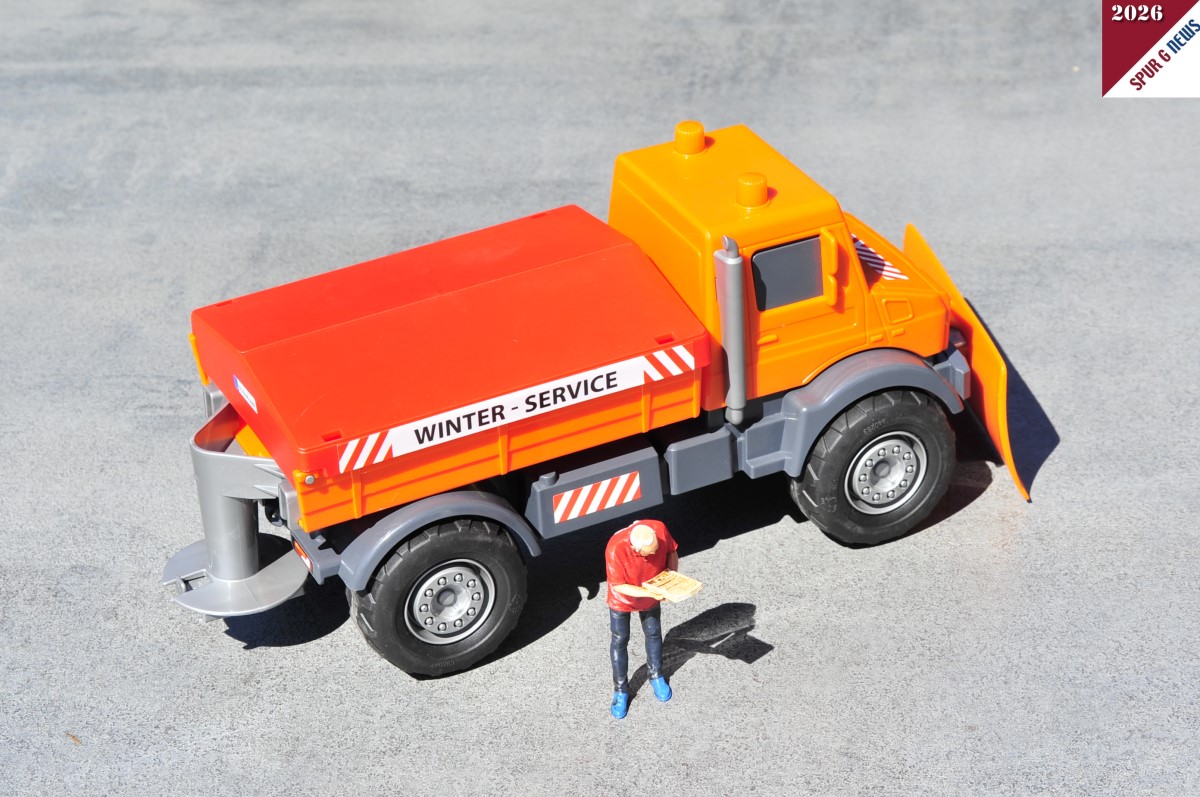 Seitenansicht des Mercedes-Benz Unimog Winter-Service. Am Heckdes Unimog ist die "Streuvorrichtung" angebracht. Die Ladefläche ist mit einem abnehmbaren roten Kunststoffdeckel geschlossen. (Die Figur ist nicht im Preis enthalten.)