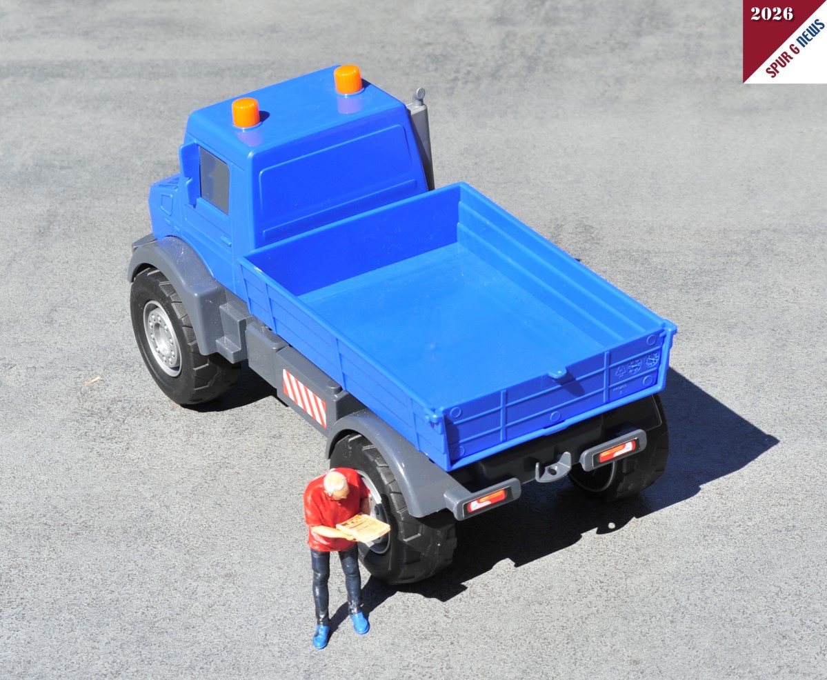 Rückansicht des Mercedes-Benz Unimog Kipper. Die Ladefläche kann nach oben gekippt werden und die Heckklappe ist für die Entladung beweglich. (Die Figur ist nicht im Preis enthalten.)
