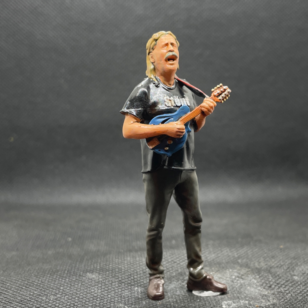 Figur: Stoenf. Er zupft die Seiten der Gitarre und schmettert die Lieder dazu! .