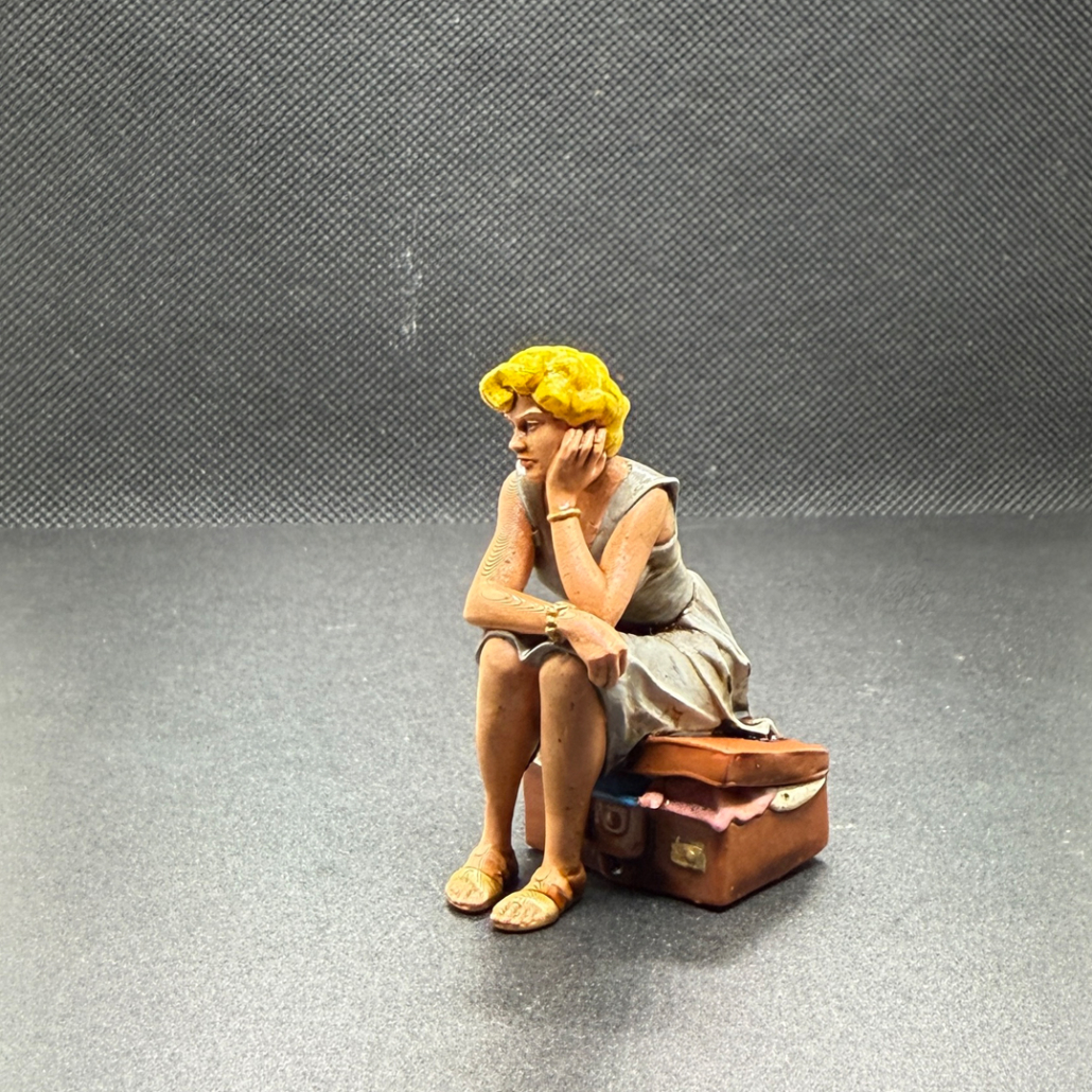 "Diana" - sitzt auf einem gepackten Koffer und denkt nach wie sie den zubekommt oder wohin die Reise gehen soll. 