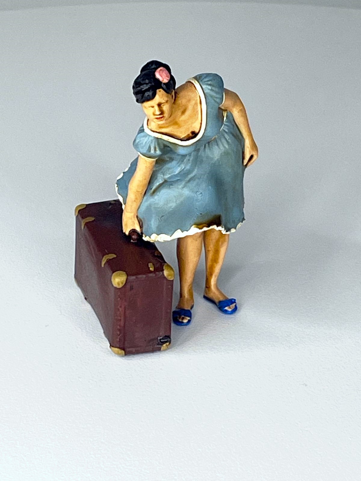 Die Frau im blauen Kleid mit Reisekoffer. Wie im richtigen Leben: Der Koffer ist f�r die Reise gepackt. 