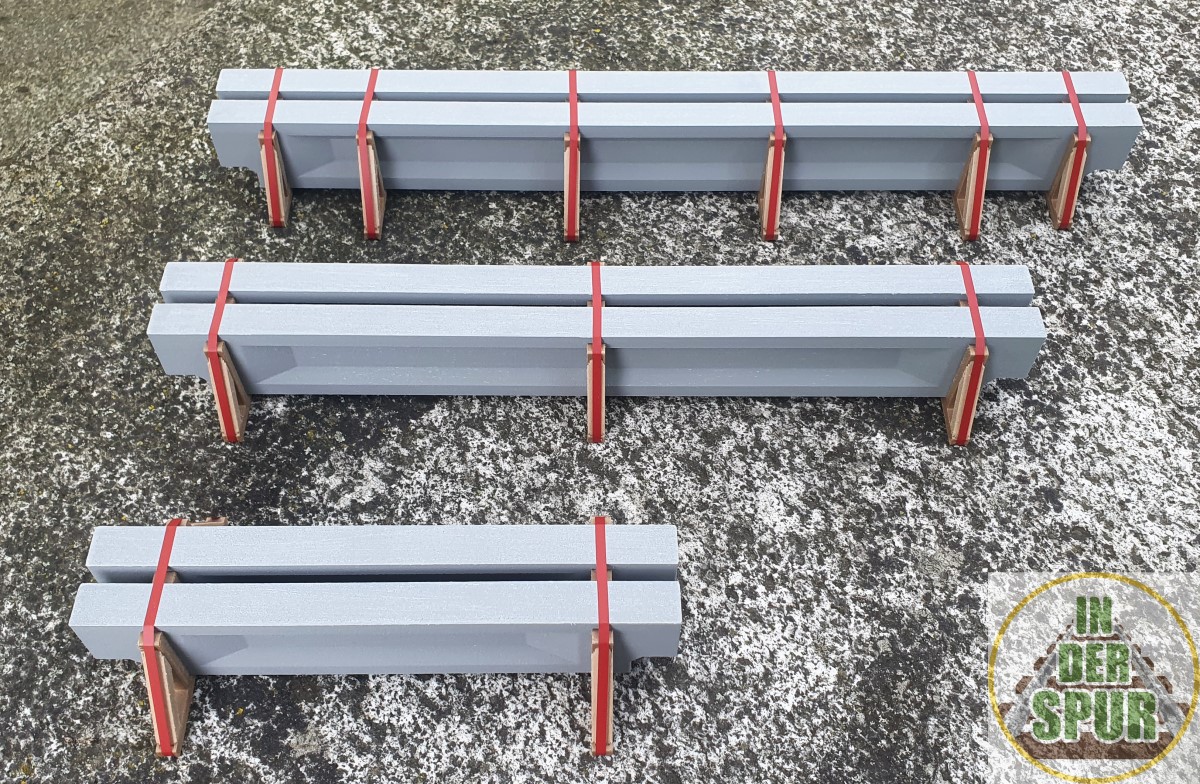 Damit das Ladegut zu unterschiedlichen Fahrzeugen passt, stehen drei Ausführungen mit einer Länge von 23 cm, 40 cm und 48 cm zur Auswahl. Jede Ladeeinheit besteht aus zwei Betondeckenträgern in grauer Betonoptik (wetterfestes Spezialmaterial). Nachgebildete Holzunterlagen und auffällige rote Zurrgurte sorgen für eine glaubwürdige Transportsicherung. Die Ladungen werden vormontiert geliefert und sind sofort einsatzbereit.