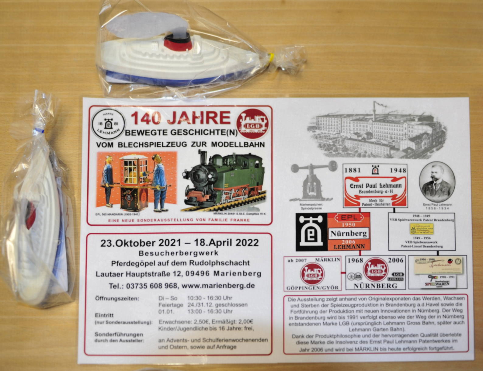 Das Bild zeigt das Motto der Ausstellung, die Öffnungszeiten mit Adresse und auf der rechten Seite die stark vereinfachte Darstellung über WERDEN, WACHSEN und STERBEN der Blechspielzeugproduktion in Brandenburg.
