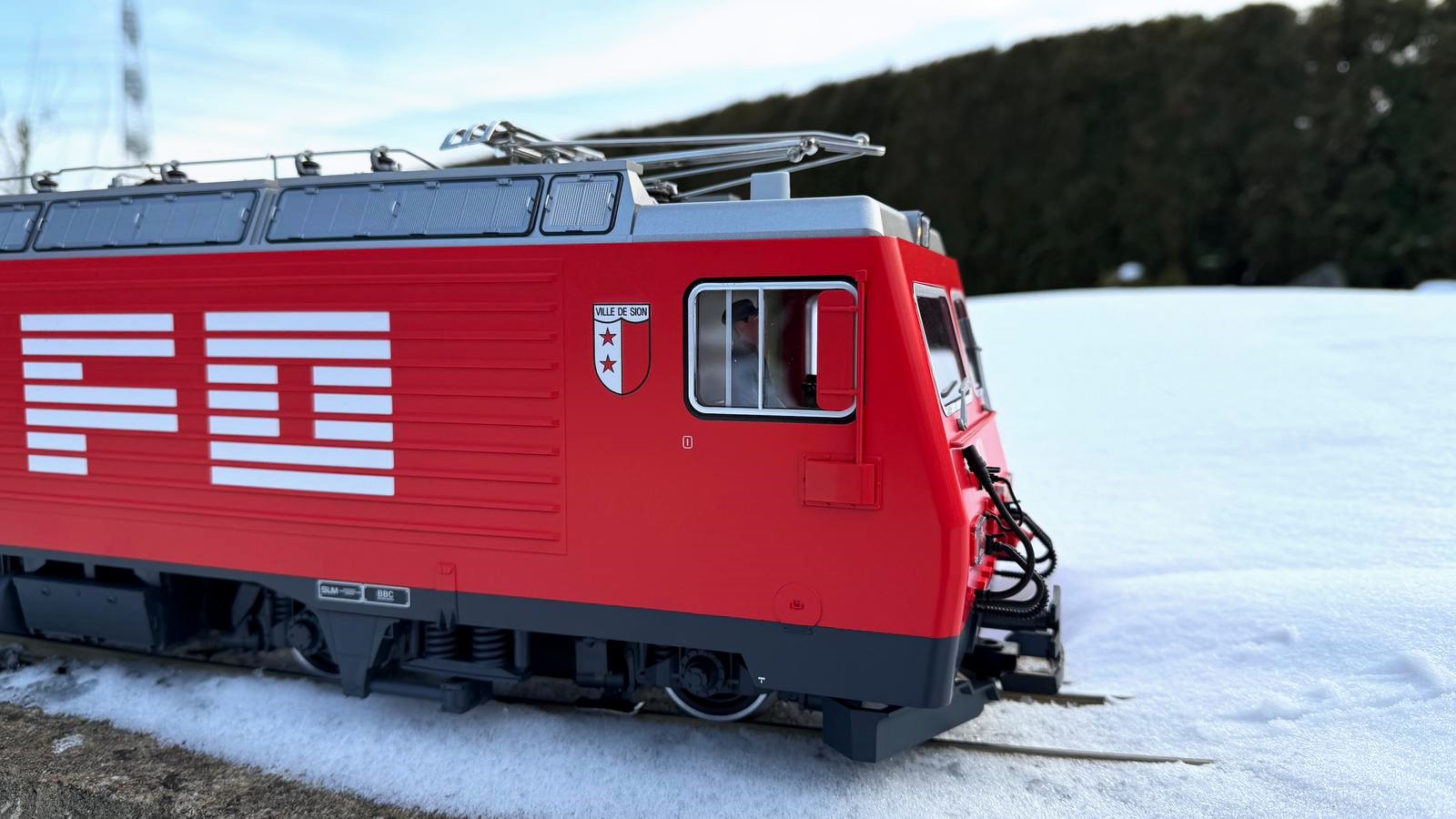 Kurz vor einem Stopp im Schnee: HGe 4/4 II der FO Nr. 101 - Art. Nr. 23103 von LGB - Herbstneuheit 2025. Logo der FO und das Wappen in hervorragender Bedruckung.