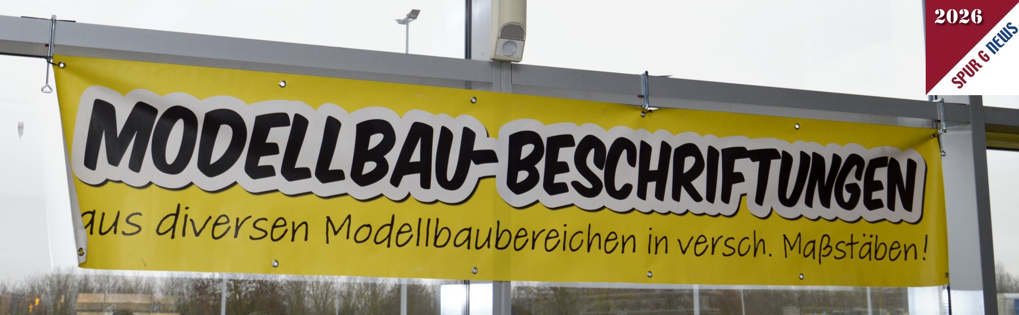 Beim R�ckweg zum Ausgang und zum Pressecenter ist mir Foyer noch ein Banner mit "Modellbau-Beschriftungen" ins Auge gefallen. Hier habe ich dann auf der WEB Seite: www.modellbau-beschriftung.de  nachgesehen welche Produkte angeboten weden. Unter anderem sind RhB Beschriftungen, DR Beschriftungen und KfZ Kennzeichen f�r den Spur G Ma�stab zu erwerben. Wer sein eigenes Kennzeichen m�chte kann dies auch bei der Druckfirma bestellen. 