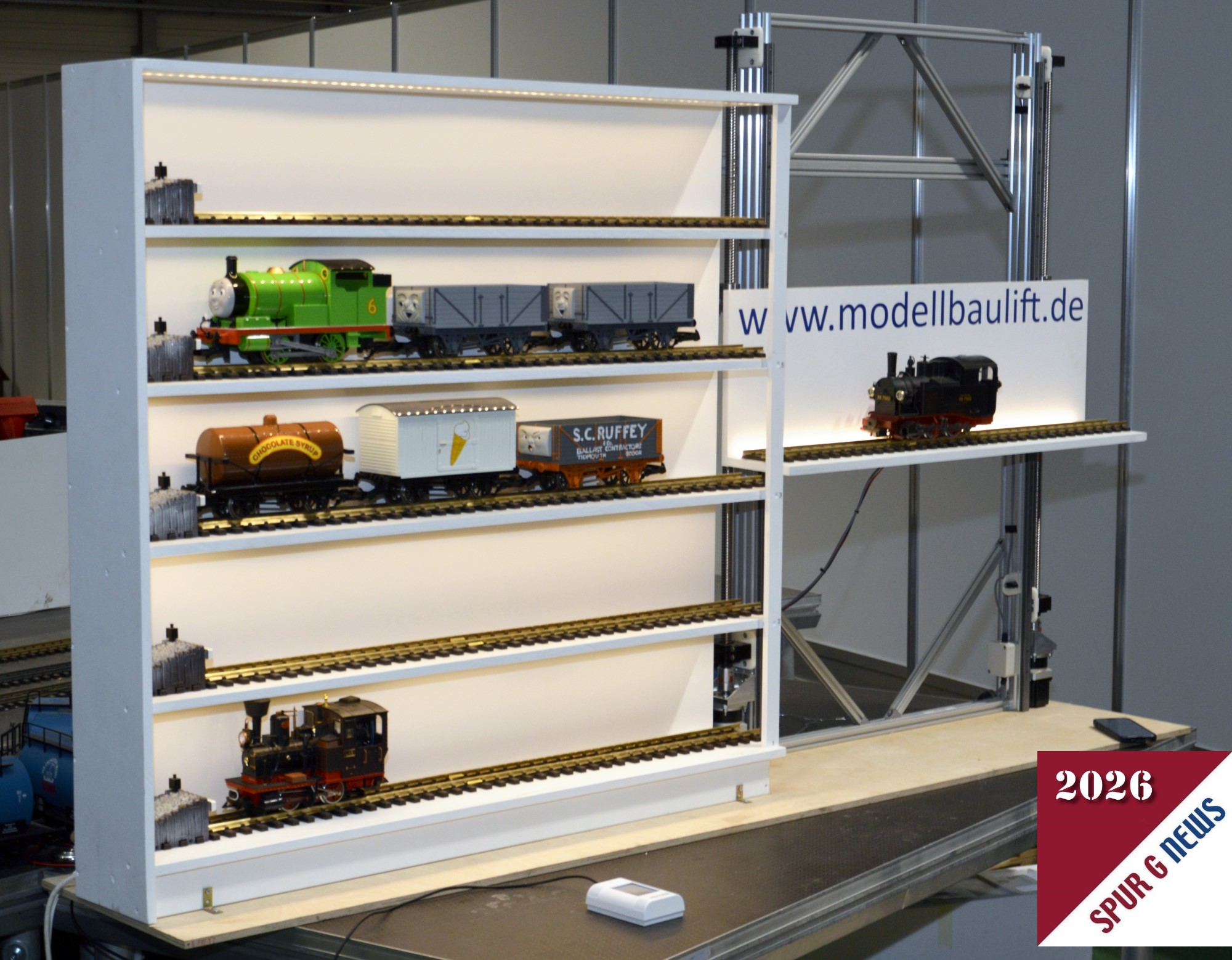 In Halle 3 wurde von der Firma www.modellbaulift.de ein Regal zur Aufbewahrung kleiner Z�ge bzw. Lokomotiven mit angebauten Lift gezeigt. Durch diese Konstruktion kann im Innenbereich ein Zugwechsel mit Lift erfolgen. Nach dem Spielen ist dann die Ausstellung in dem Vitrinenkasten zu sehen. 