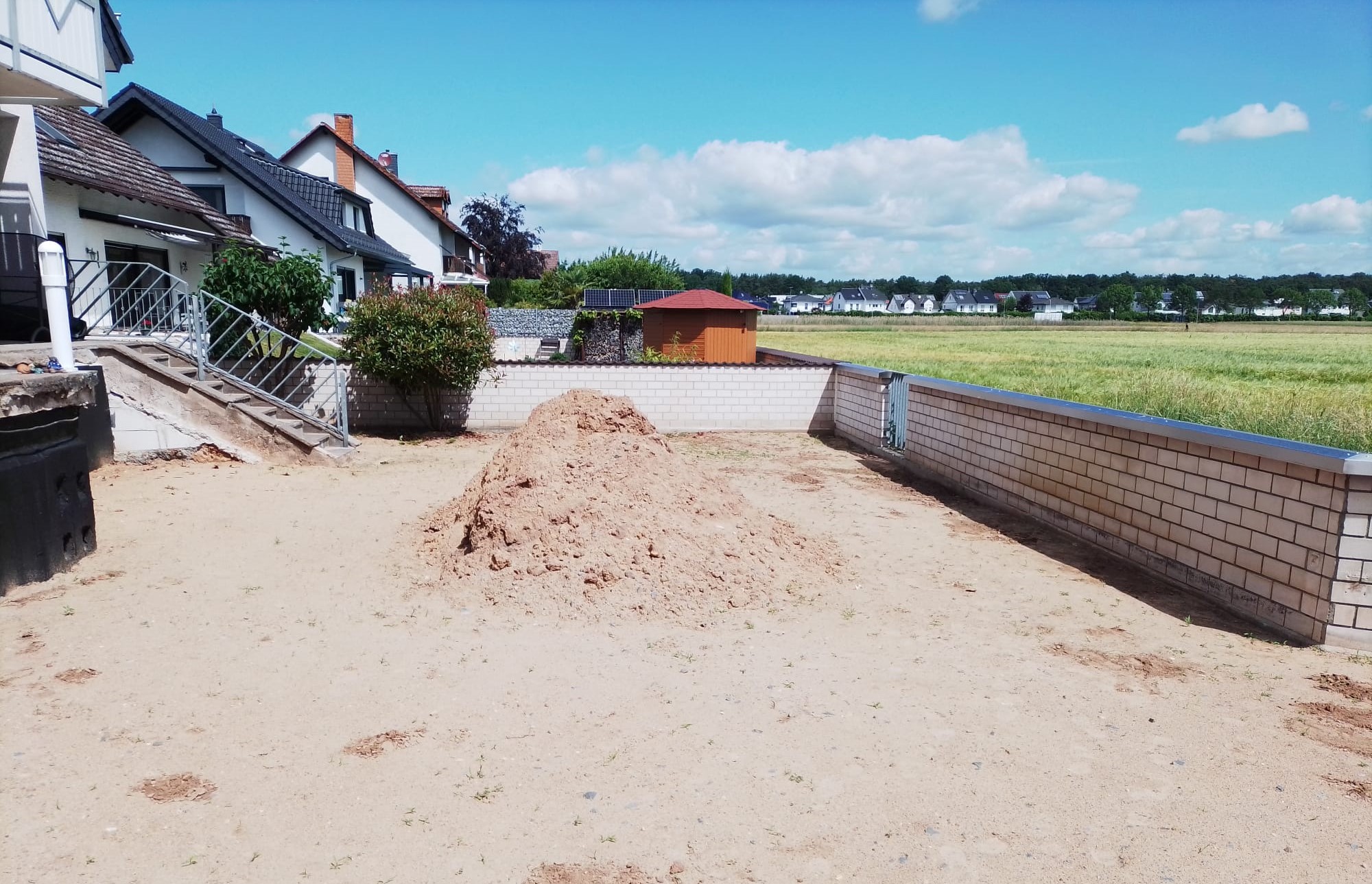 Der Garten vom Gr�n befreit.  Links ist die Treppe zum Haus erkennbar. So "steil" war der Hang in den Garten. Am langen Teil der Au�enmauer kommt nun der Bahnhof hin. Soviel sei schon vorab gesagt: Auf der Anlage kann, durch Austausch des Bahnhofsgeb�udes mit RhB, Harz und USA gefahren werden. 