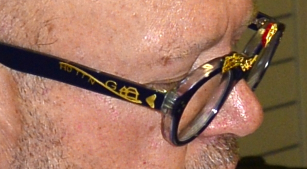 Auf dem rechten Brillenbügel sind die Produkte in als Piktogramme in Gold aufgesetzt: H0, TT, N, G, Häuser und eine Linie deutet die Gleise an. 