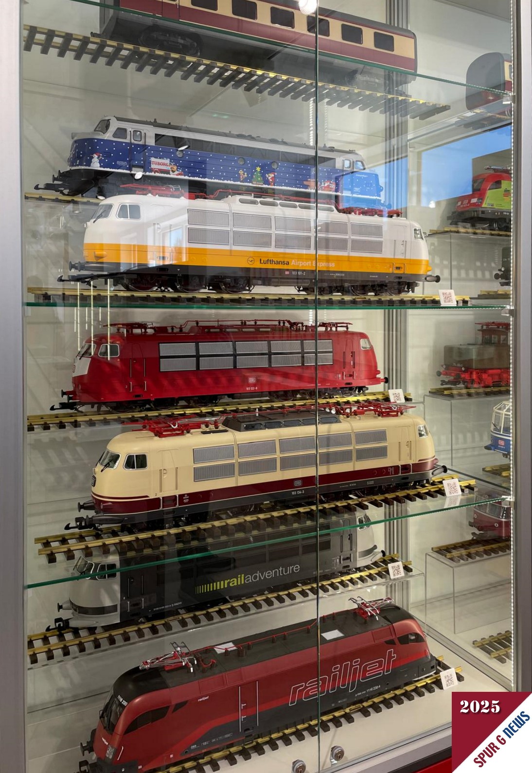 Ausschnitt aus der großen Vitrine mit den PIKO G E-Loks. Das Highlight in der Mitte - immer noch - die beige-rote BR 103 der DB. Aber auch der RailJet Taurus und die NOHAB in Weihnachtsdekoration sind herrliche Stücke.