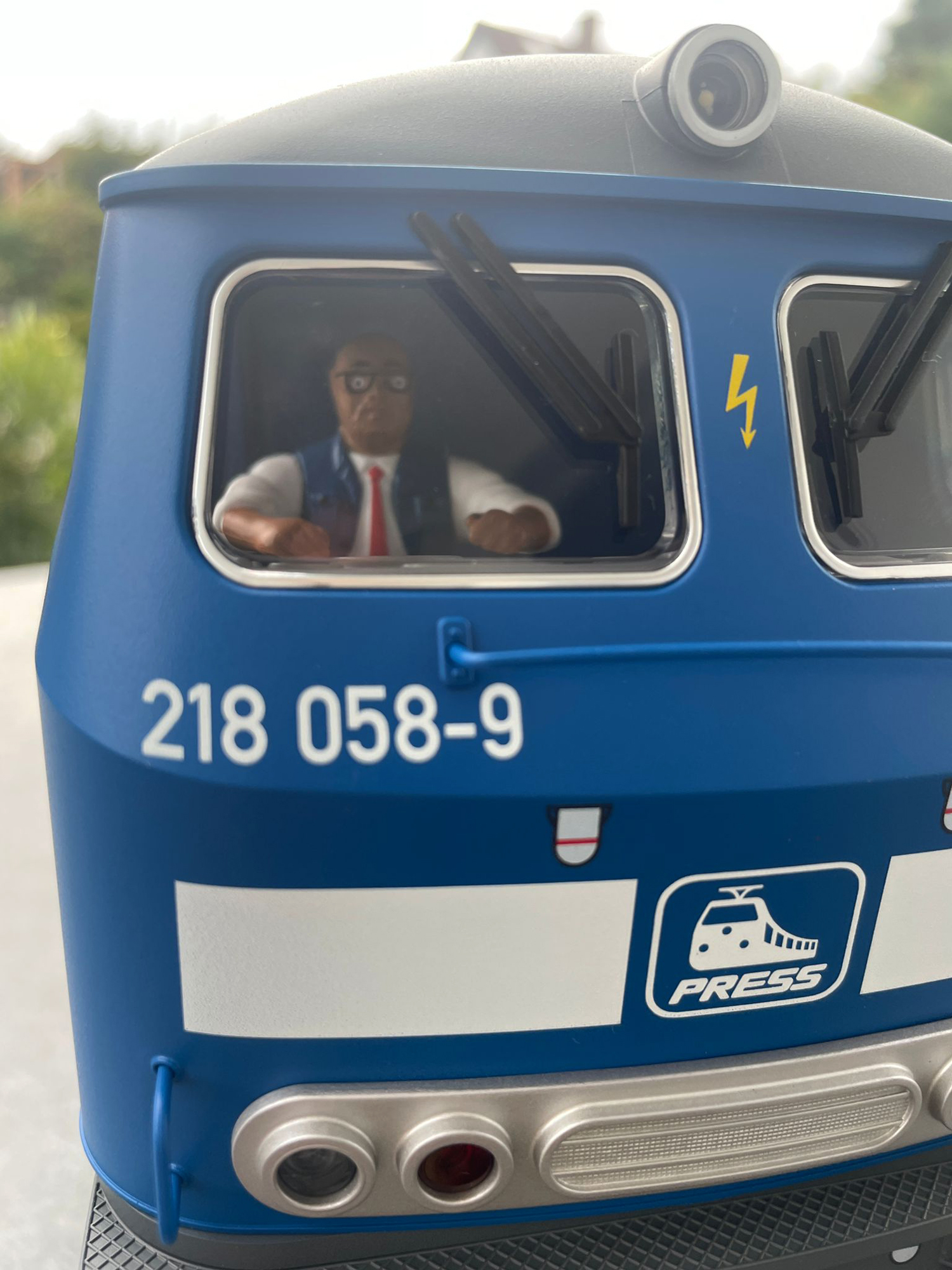 Frontpartie der Lok - sauber bedruckt. Der Warnblitz in der Mitte der beiden Scheiben, die LOK Nummer 218 058-9 und das Press-Logo ist mit Tampondruck aufgebracht. Wie immer ist der bekannte Lokfhrer in der Kanzel eingesetzt. Haltegriffe und Fensterrahmen sind ebenfalls gut lackiert. 