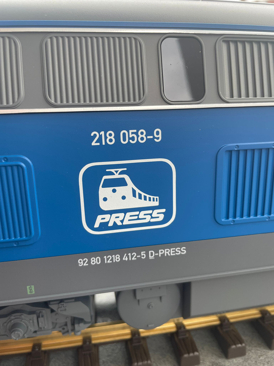 In der Mitte des Gehuses ist die Betriebsnummer 218 058-9 und das Press Logo zwischen die Lftergitter gedruckt. So wie es im Original auch zu sehen ist. 
