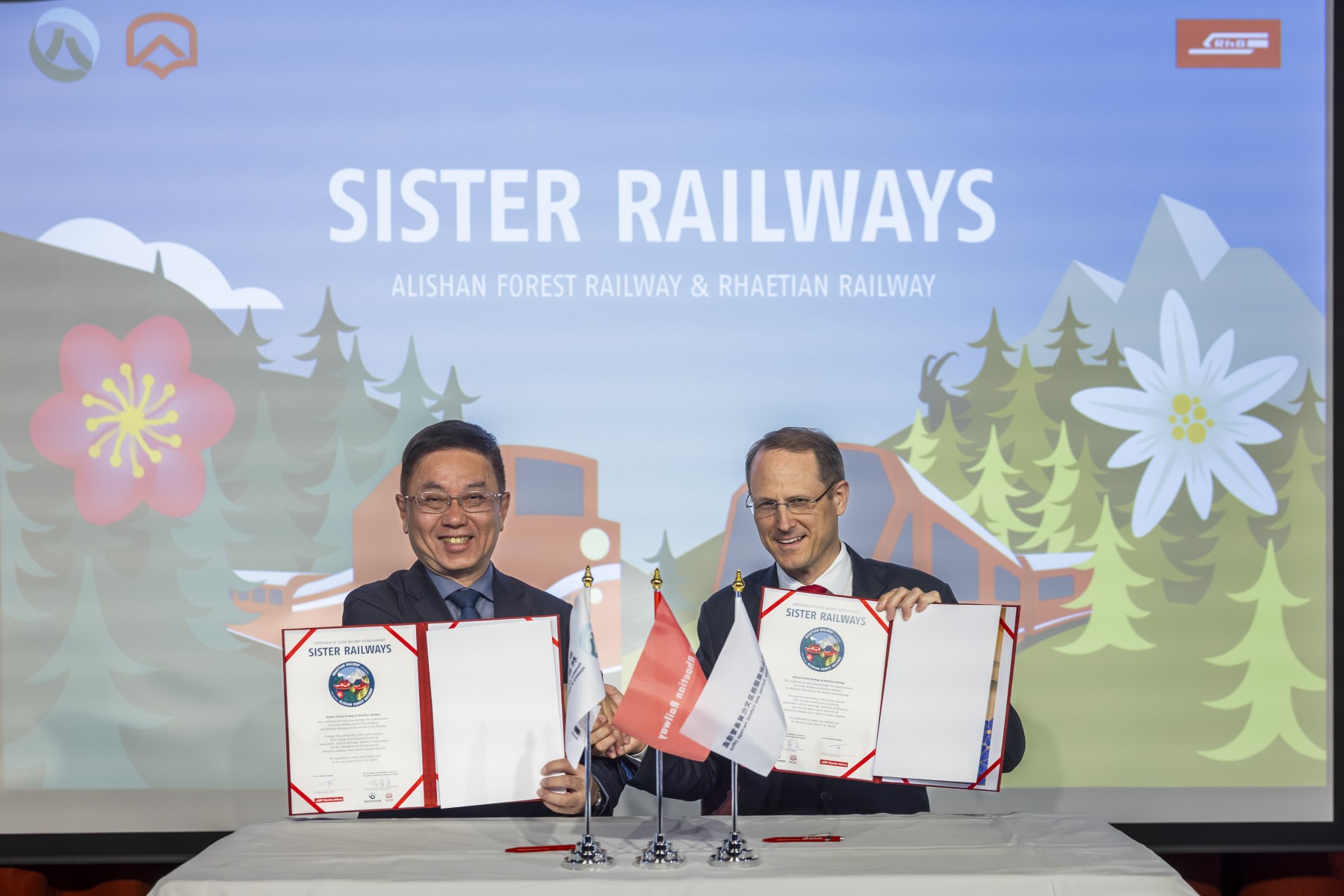 Die Urkundenunterzeichnung der RhB und der Alishan Forest Railway fand im Rahmen einer kleinen Feier im Theatersaal des Hotel Reine Victoria in St. Moritz statt. In seiner Begr�s-sungsrede betonte RhB-Direktor Dr. Renato Fasciati die Wichtigkeit solcher Partnerschaften: �Es freut uns sehr, mit Alishan Forest Railway eine weitere Partnerbahn aus Asien gewonnen zu haben und so die internationale Zusammenarbeit im Eisenbahnwesen weiter st�rken zu k�nnen�. Michel Pauchard, Leiter Marktmanagement RhB meinte erg�nzend: �Asien ist f�r uns ein wichtiger Markt, in welchem wir derzeit mit einem Marktverantwortlichen und sechs Sales Repr�sentanten aktiv sind. Neue Partnerschaften bedeuten neue Opportunit�ten�. Partnerbahnen der Rh�tischen Bahn | Rh�tische Bahn